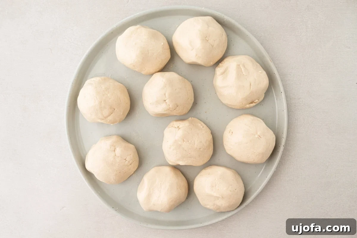 Grain-Free Cassava Wraps 7 Ten uniformly portioned cassava dough balls arranged on a round plate, covered with a damp towel.