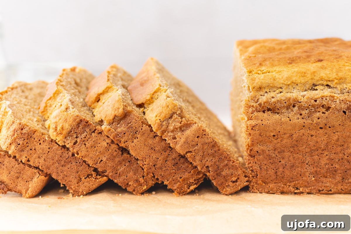 Tropical Root Bread 10 Sliced loaf of cassava bread resting on parchment paper, showing a crisp crust and soft interior.