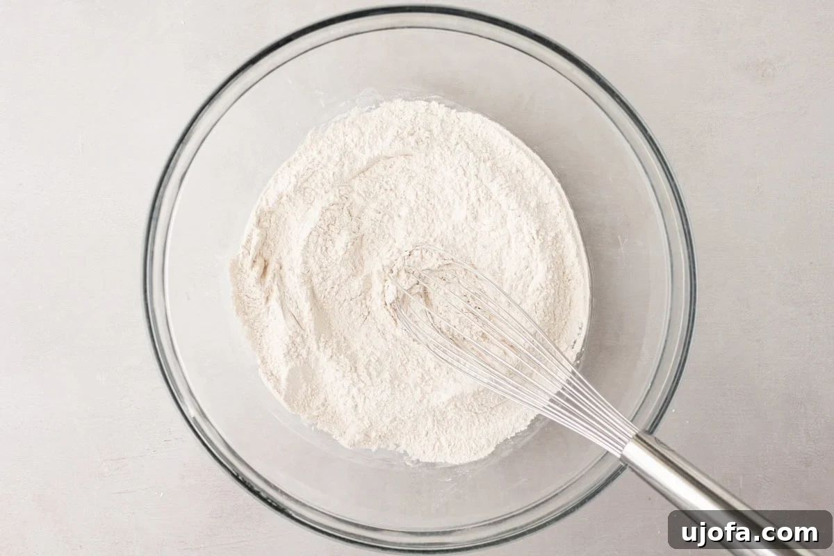 Tropical Root Bread 5 Glass bowl with a whisk resting in a pile of dry flour mixture, ready for baking cassava bread.
