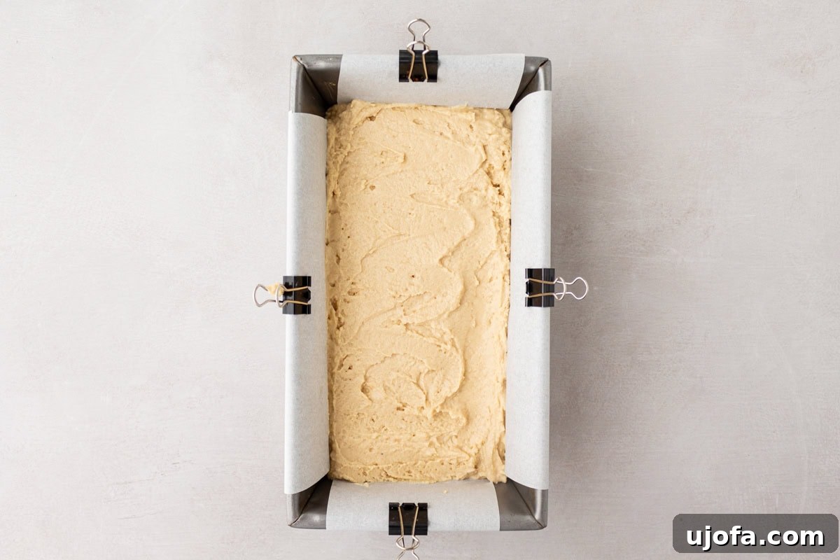 Tropical Root Bread 8 Cassava bread batter spread evenly into a parchment-lined loaf pan, clipped on the sides to hold the paper in place.