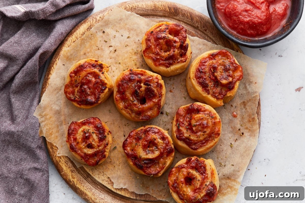 A rustic wooden serving tray laden with an array of finished, perfectly baked gluten-free pizza rolls, garnished with fresh basil, ready to be enjoyed.