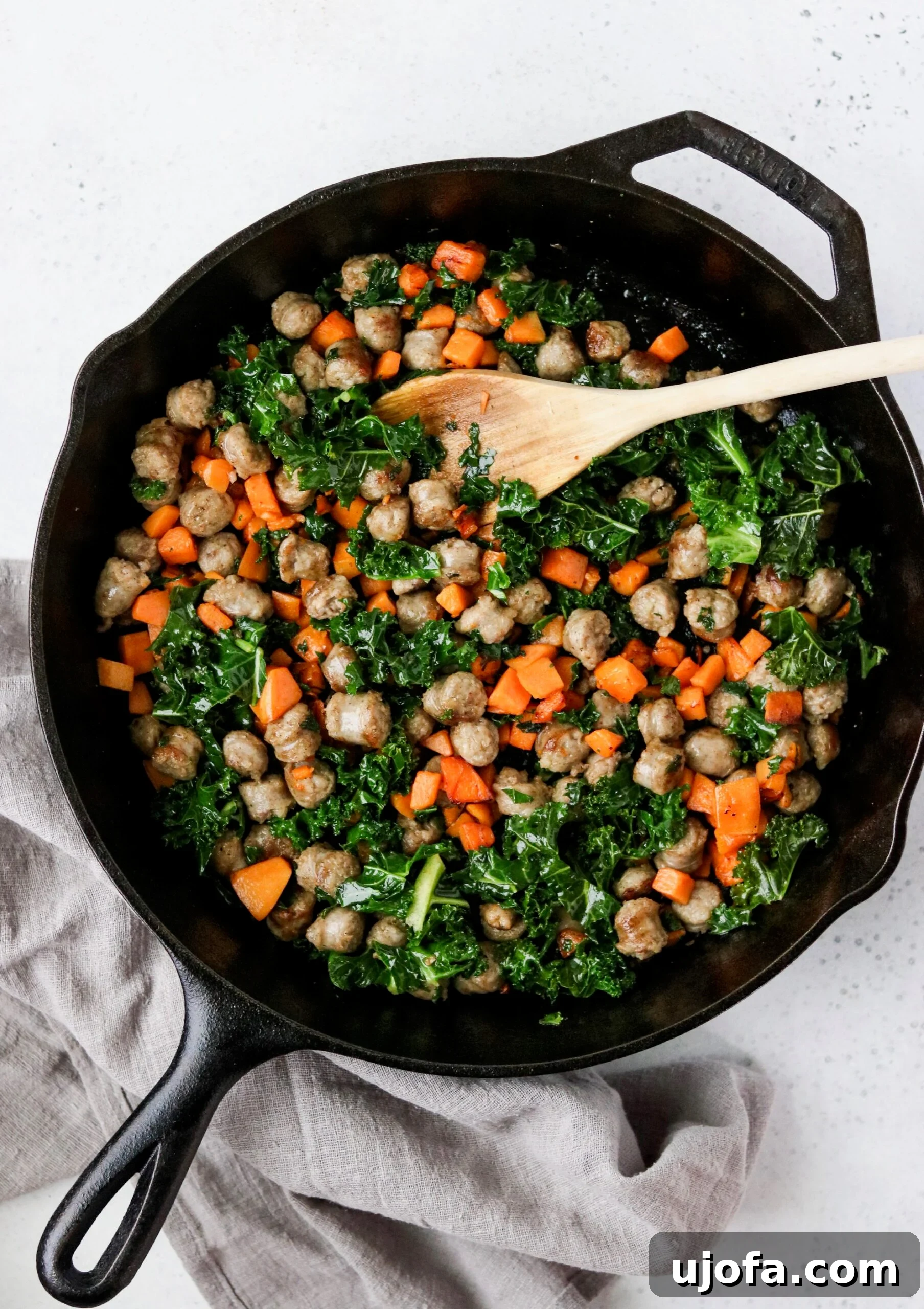 Savory Sausage, Sweet Potato, and Kale Egg Bites Whole30 Paleo 3 Ingredients for sausage, sweet potato, and kale egg cups being prepared in a skillet.