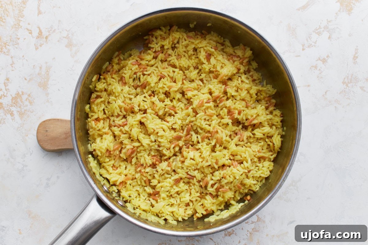 Fluffy, golden gluten-free rice pilaf in a pan, with tender rice and pasta grains perfectly cooked and mixed.