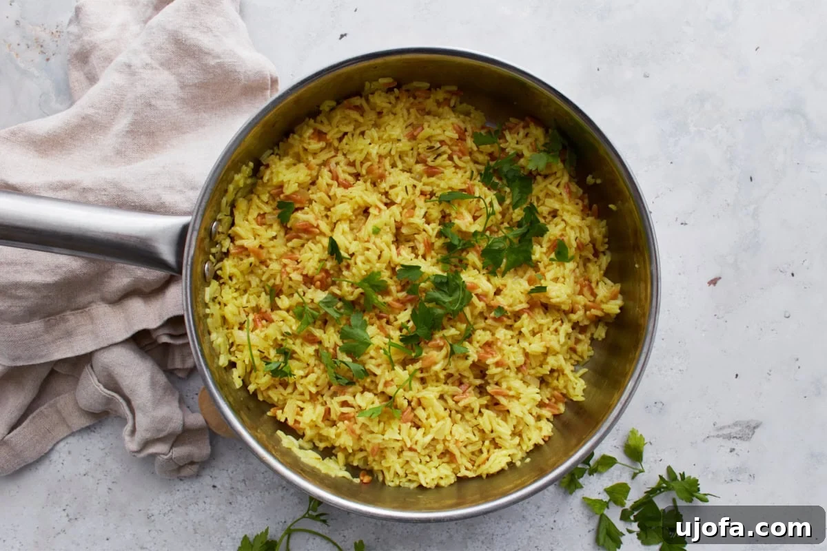 A pot of freshly cooked gluten-free rice pilaf, generously garnished with vibrant green fresh parsley, ready for serving.