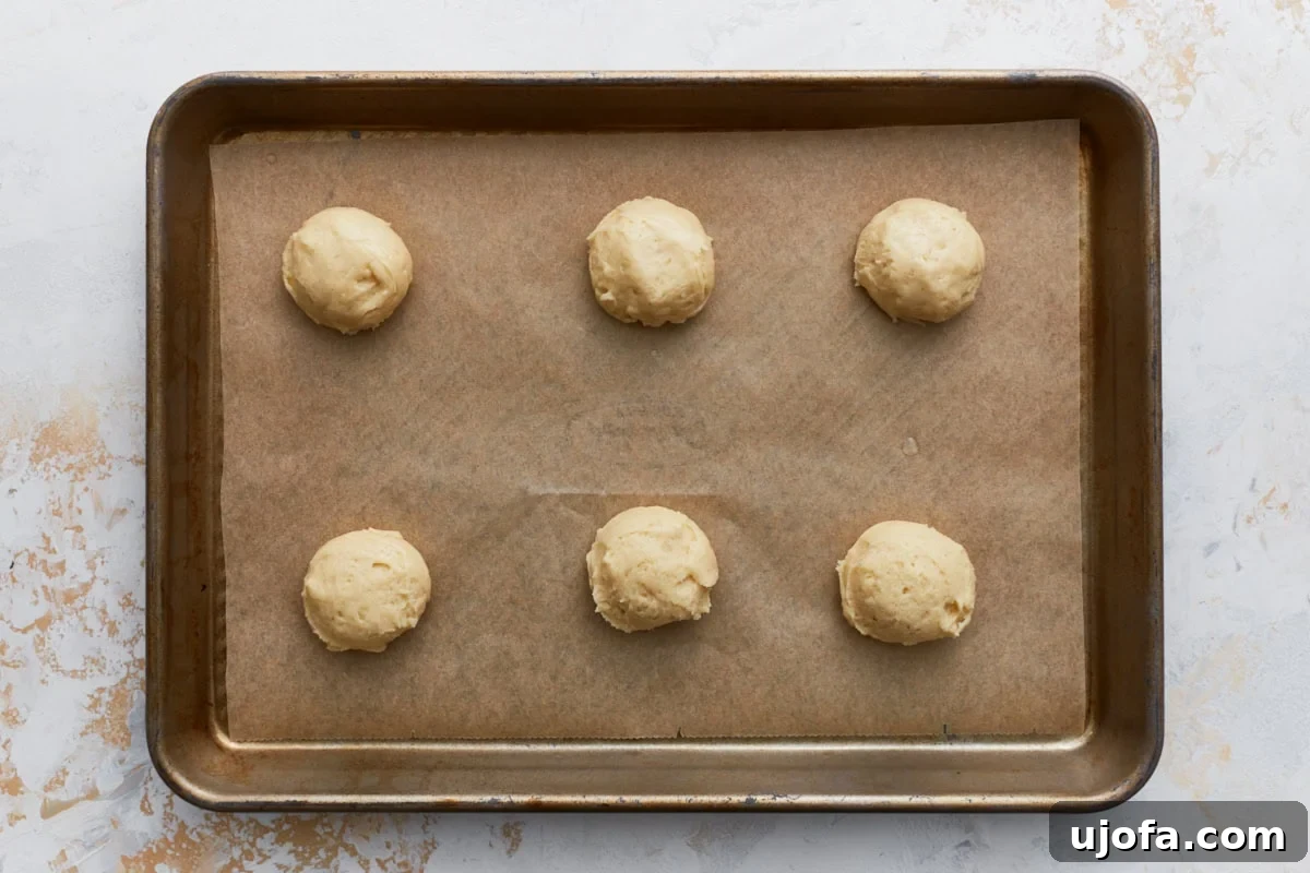 Pure Vanilla Gluten-Free Wafers 8 Six rounded scoops of cookie dough spaced out on a parchment-lined baking sheet, ready to bake.