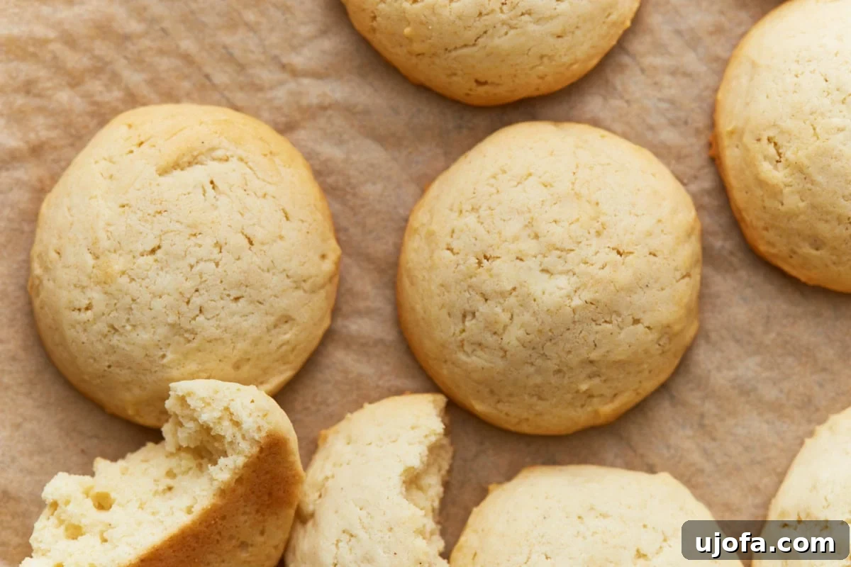 Pure Vanilla Gluten-Free Wafers 9 Freshly baked vanilla wafers cooling on a baking sheet, slightly puffed with golden edges.