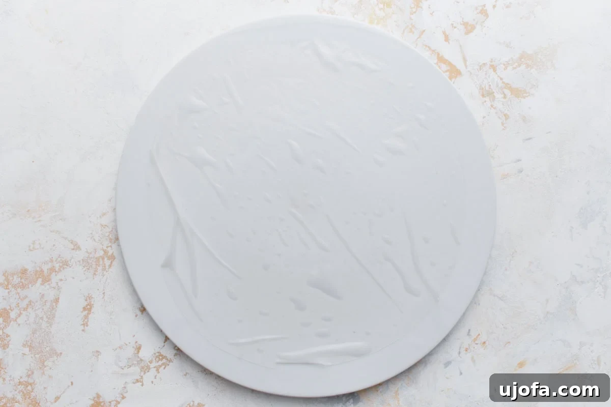 A softened rice paper wrapper resting on a clean white surface, ready to be filled.