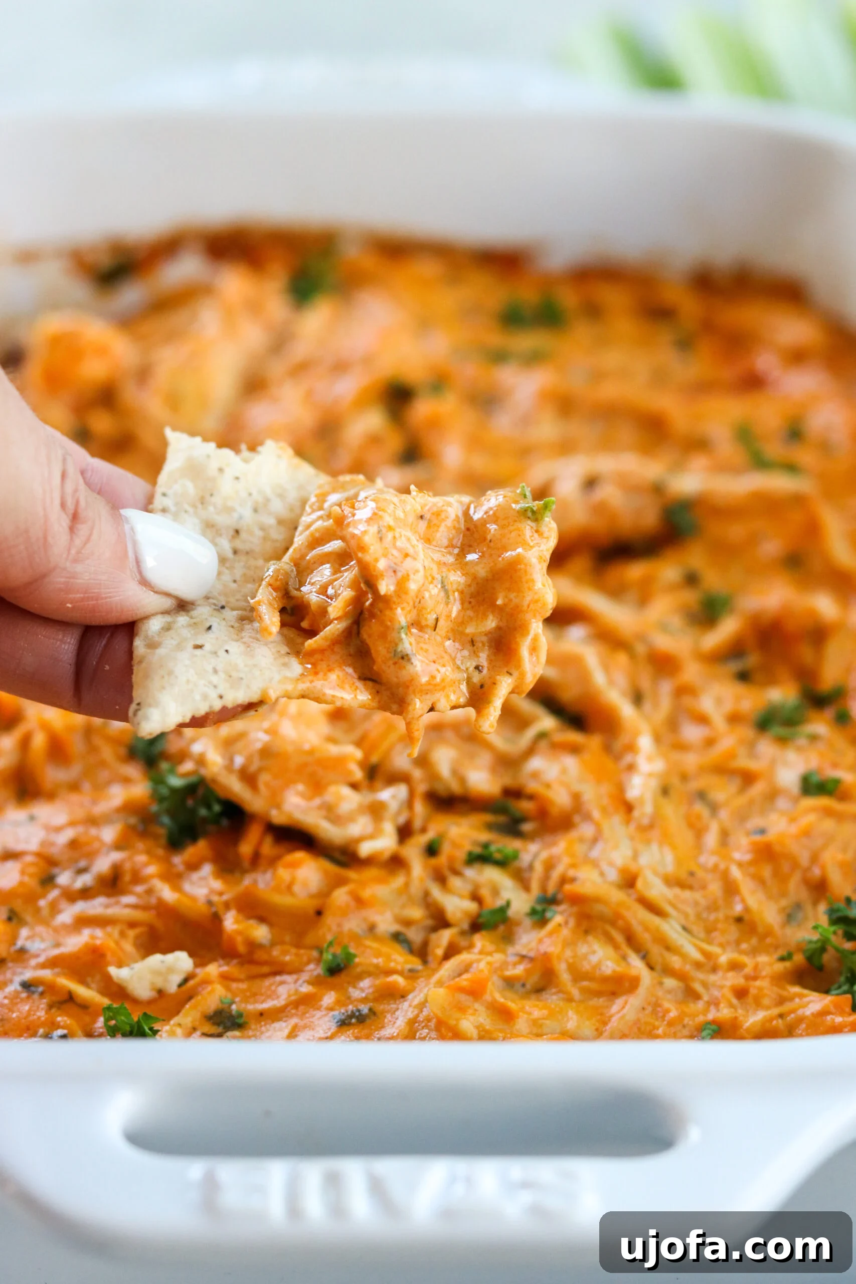 Easy Instant Pot Keto Buffalo Chicken Dip No Dairy 5 A hand with a chip scooping up some buffalo chicken dip