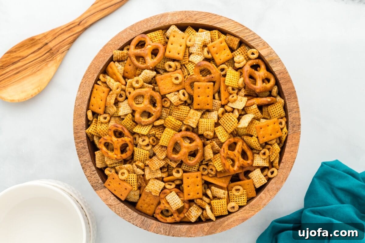 Savory Gluten-Free Party Mix 8 Overhead image of gluten-free Chex Mix served in a wooden bowl with a wooden spoon and teal cloth nearby.