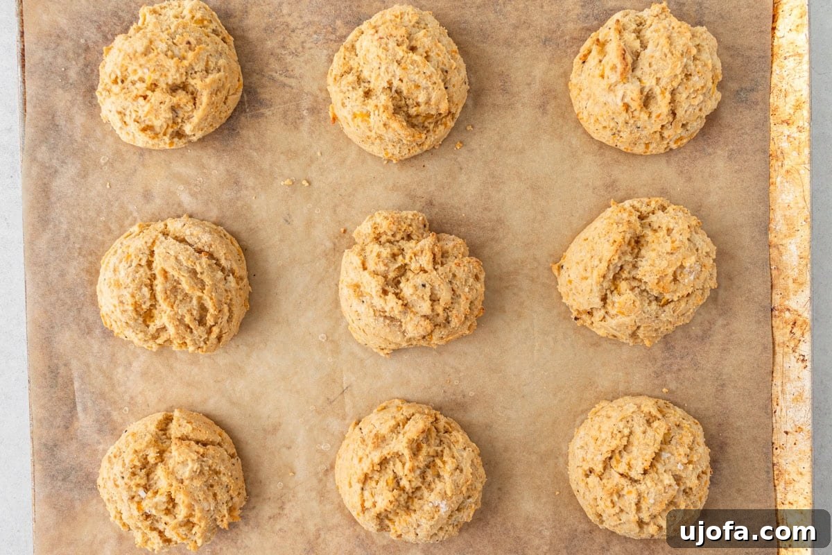Fluffy Gluten-Free Drop Biscuits 10 A baking sheet filled with golden, fluffy, and freshly baked gluten-free cheddar biscuits, still warm from the oven.