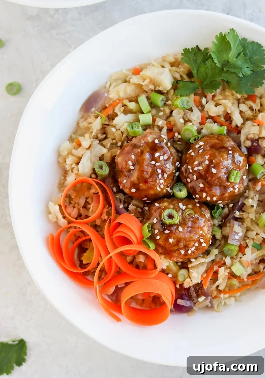Asian Pork Meatball Bowls served with cauliflower fried rice and fresh garnishes.