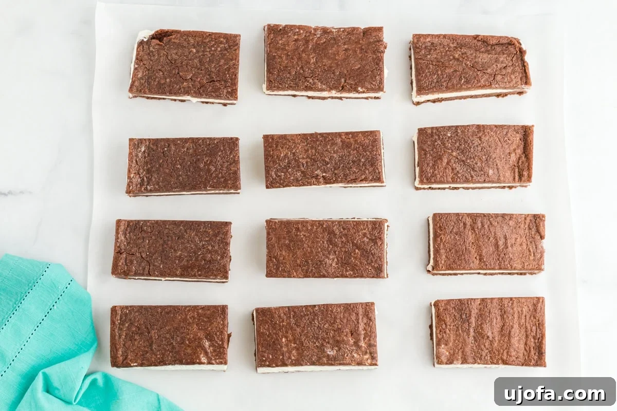 Twelve perfectly sliced gluten-free ice cream sandwiches, ready for serving or individual wrapping, neatly arranged on parchment paper.