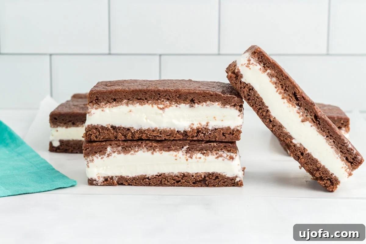 Close-up of deliciously stacked gluten-free ice cream sandwiches, highlighting the creamy vanilla ice cream nestled between two rich, chewy chocolate cookie layers.