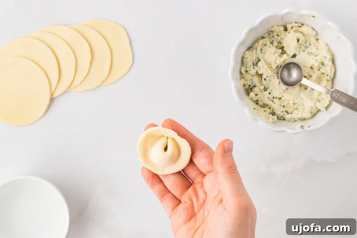 Fully shaped gluten-free tortellini with sealed edges and center pressed into the classic ring shape