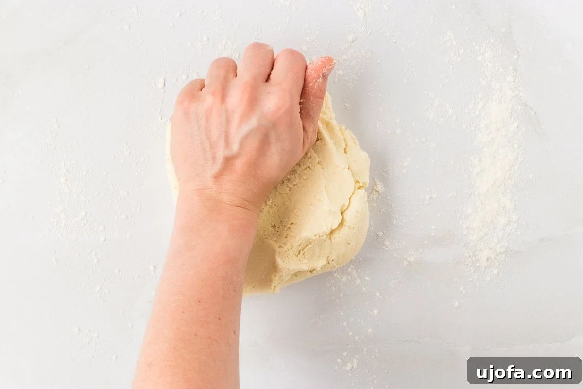 Hand kneading gluten-free pasta dough on a floured surface
