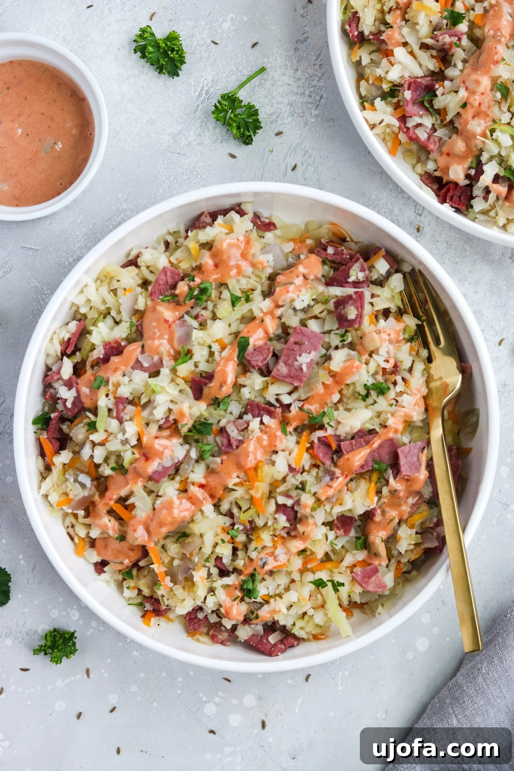 A hand drizzling homemade Thousand Island dressing over a freshly prepared Reuben in a Bowl