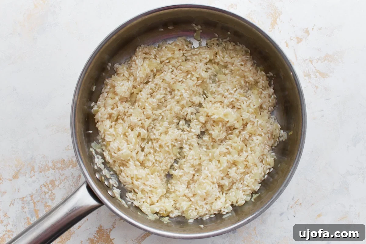 Gluten-Free Risotto Bliss 8 Arborio rice toasted in the pan, being deglazed with dry white wine, which is visibly bubbling and absorbing into the grains.