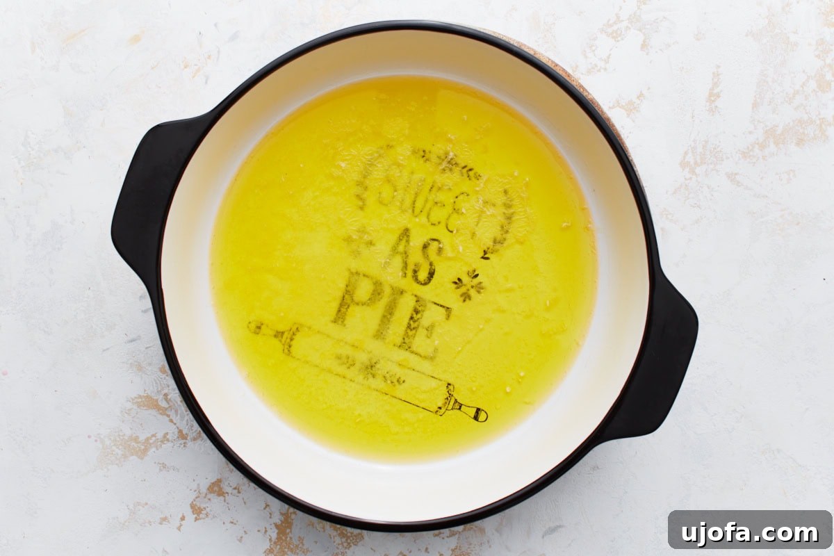 A square baking dish containing six tablespoons of melted butter, spread across the bottom, glistening golden.