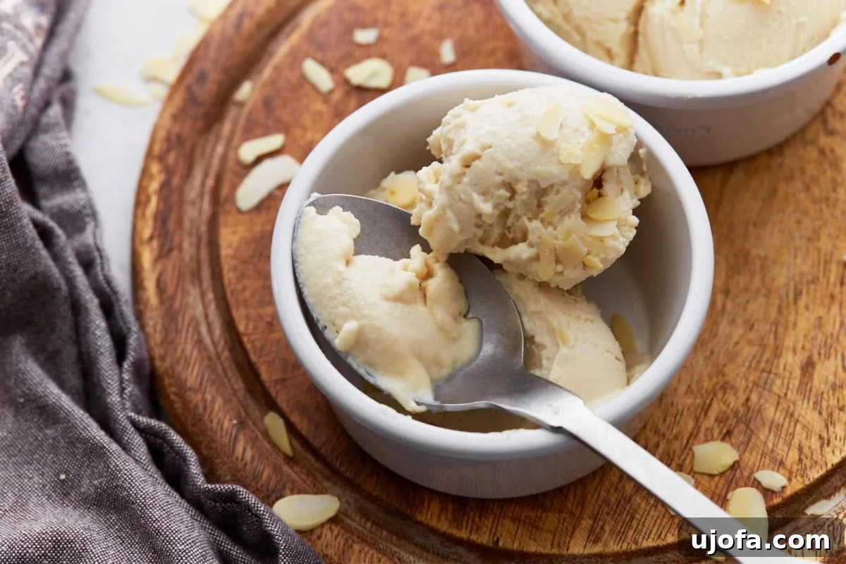 Creamy Almond Dream 11 Spoonful of almond milk ice cream being lifted from a ramekin, topped with slivered almonds.