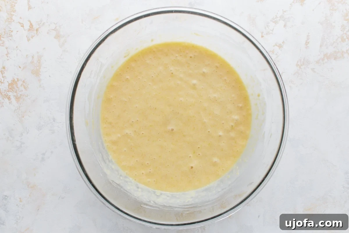 Fully mixed lemon loaf batter in a glass bowl, smooth and ready to pour.