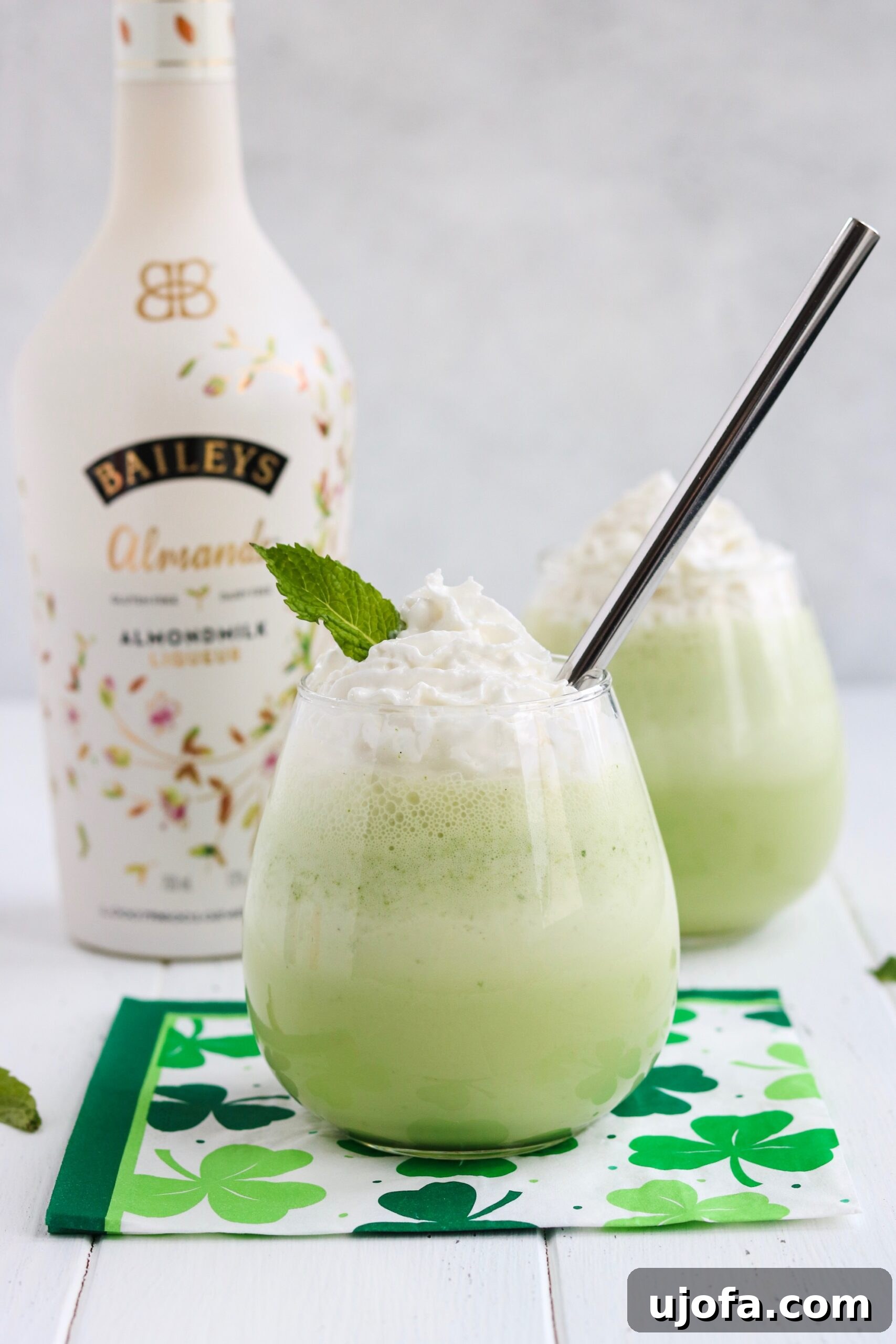 Another close-up shot of the vibrant green Spiked Shamrock Shake, showcasing its creamy texture and the inviting whipped topping, a perfect representation of a dairy-free and vegan St. Patrick's Day indulgence.