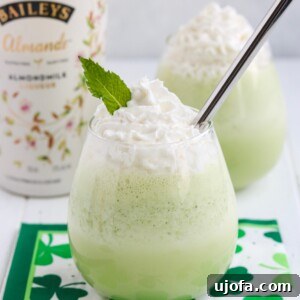 A close-up of the Spiked Shamrock Shake ready to be enjoyed, garnished with dairy-free whipped cream, perfect for a St. Patrick's Day celebration.