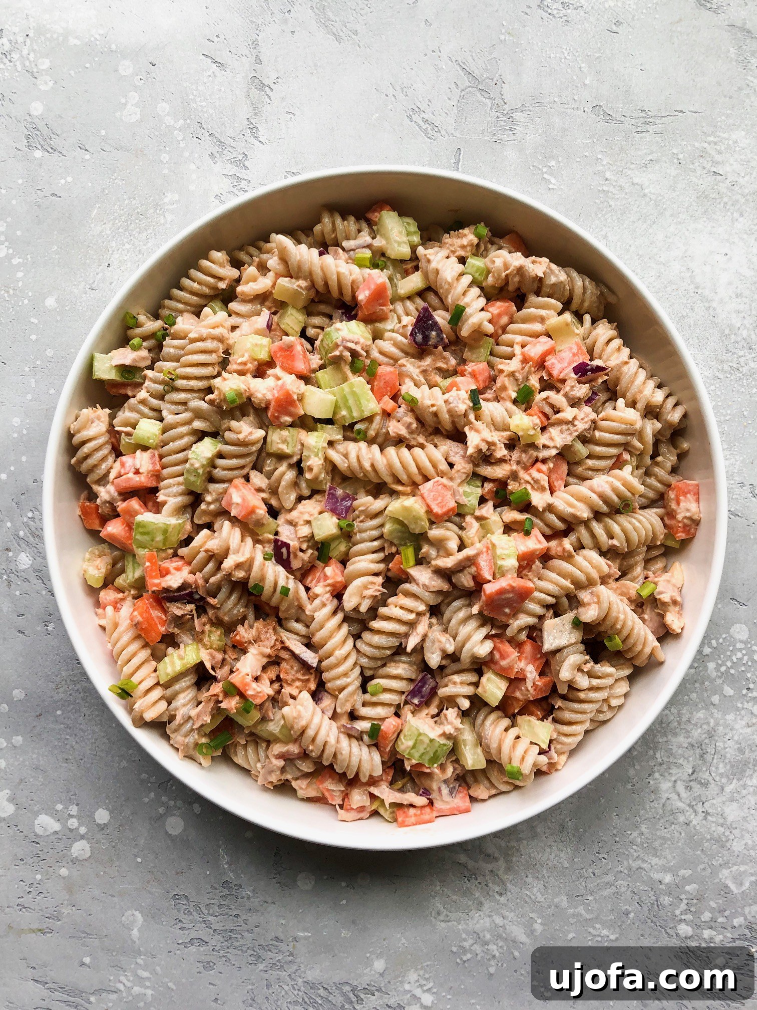 Close-up of Buffalo Tuna Pasta Salad ingredients, including diced carrots, celery, and red onion, before mixing.