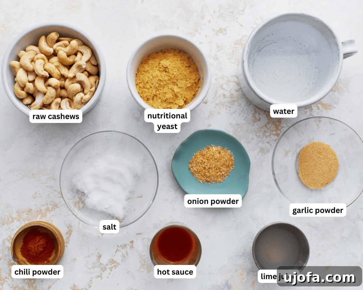 Creamy Cashew Queso 4 A top-down view of all the essential ingredients for cashew queso dip laid out on a clean surface, including raw cashews, nutritional yeast, spices, and lime.