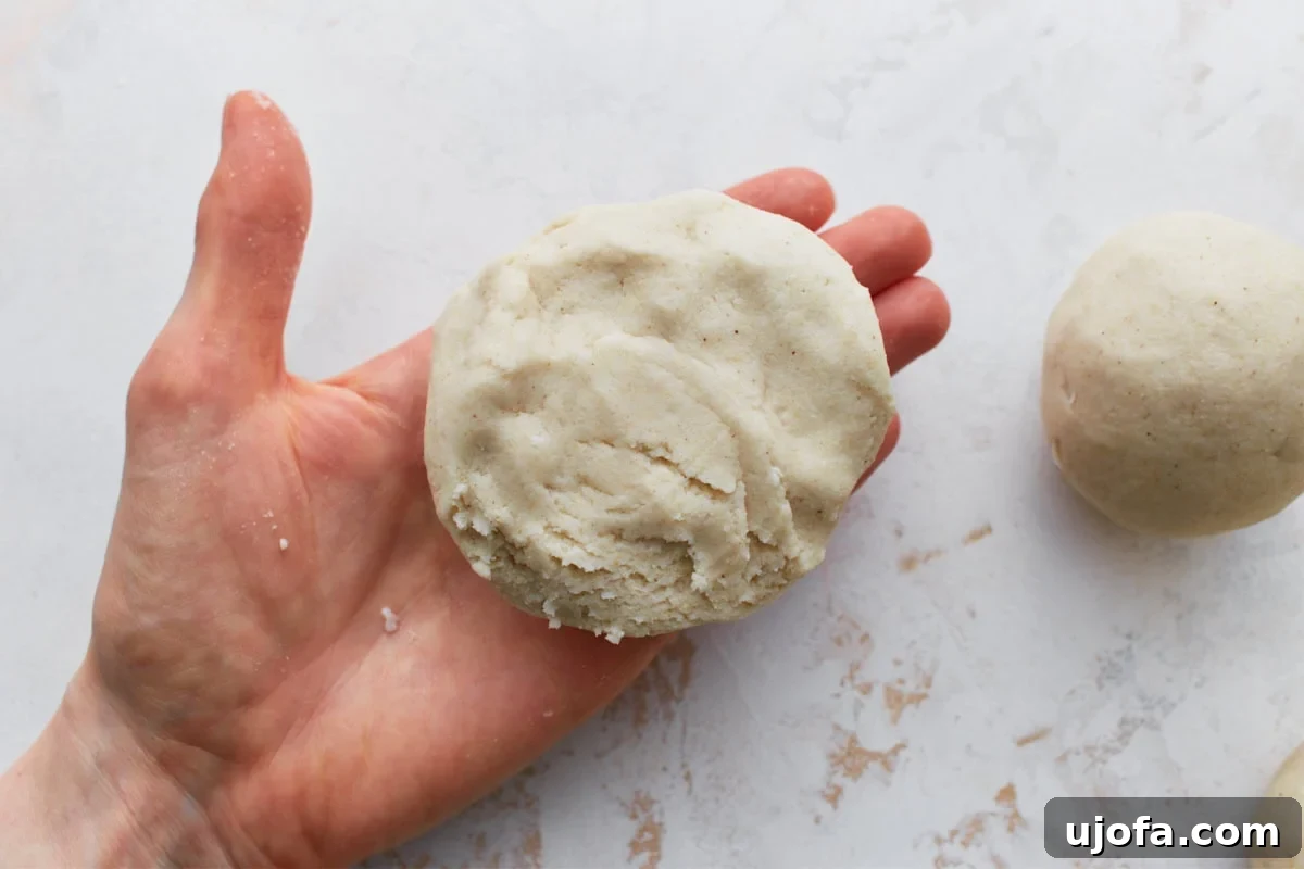 Savory Salvadoran Pockets 10 A sealed and flattened pupusa held in a hand, ready to be cooked.