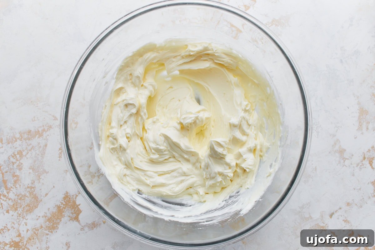 Decadent Keto Cheesecake 8 Softened cream cheese and powdered sweetener beaten until smooth in a glass mixing bowl.