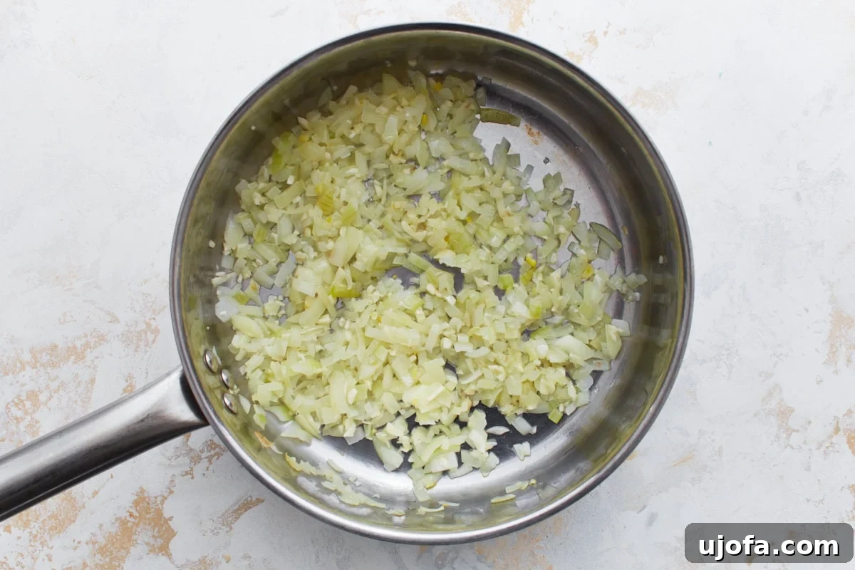 Hearty Keto Chili 5 Finely chopped onions and minced garlic sautéing in a stainless steel skillet until soft and translucent.