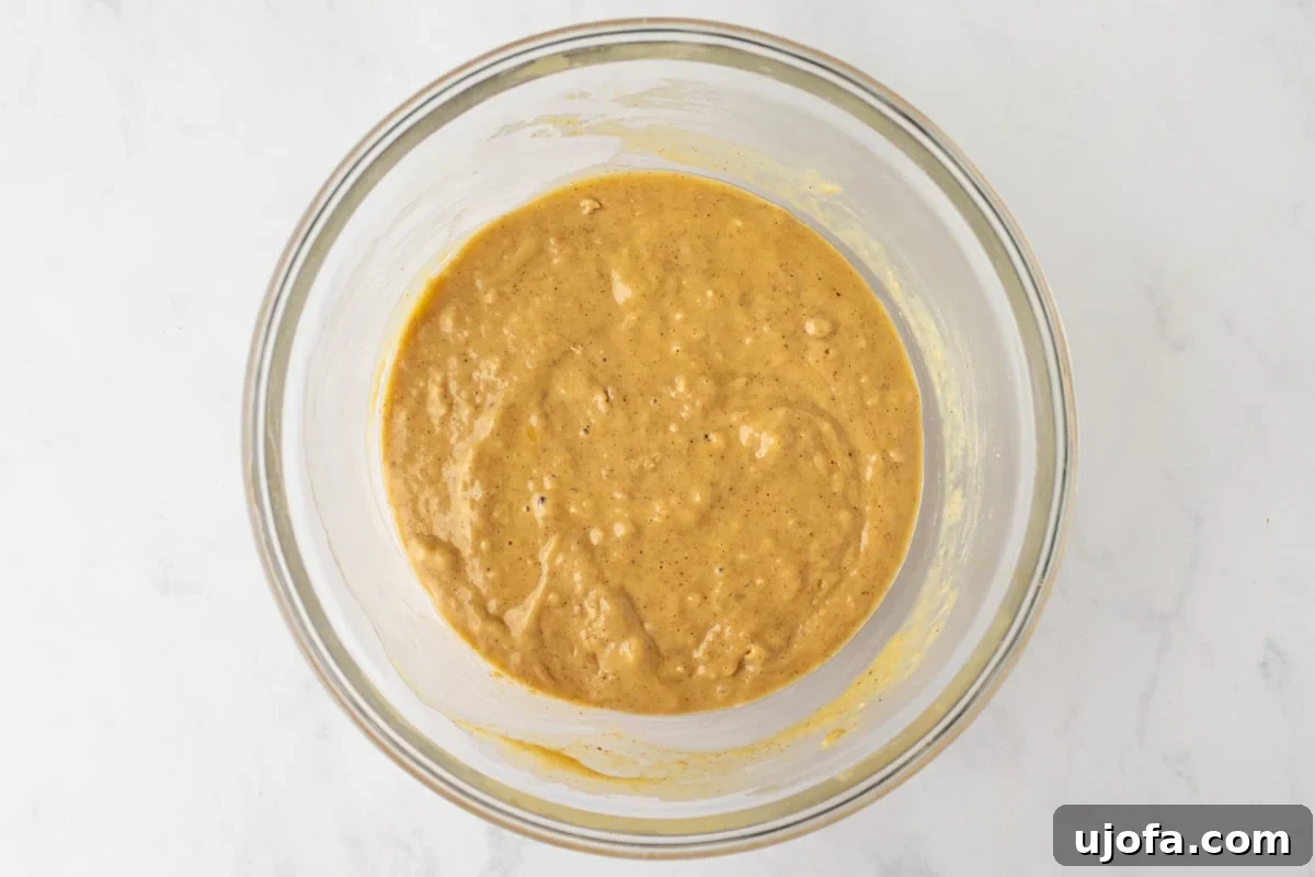 Fully mixed gluten-free spice cake batter in a bowl, ready to be poured into the pan.