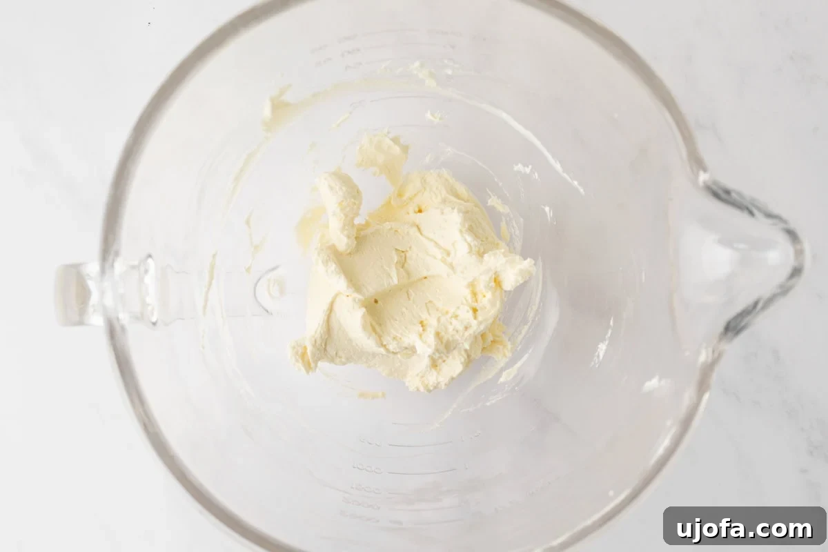 Creamed butter and cream cheese whipped together in a mixing bowl, forming the base for the frosting.