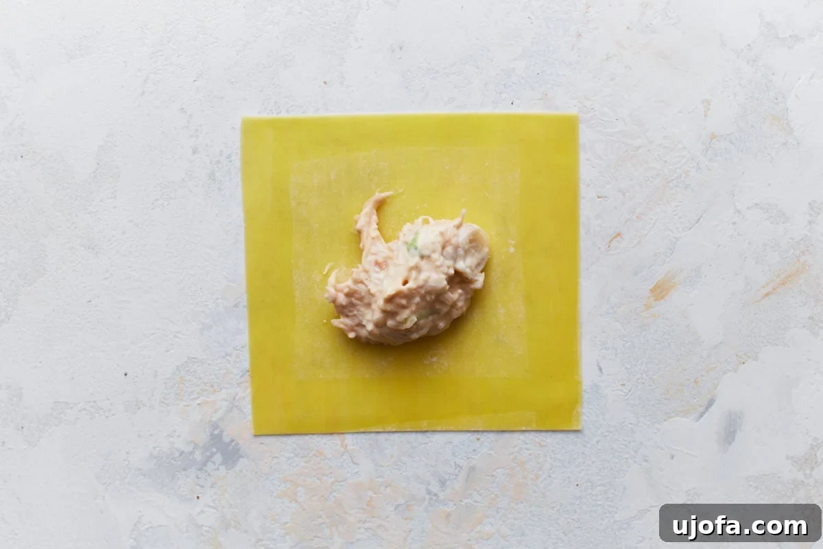 A single gluten-free wonton wrapper with a dollop of crab filling in the center.