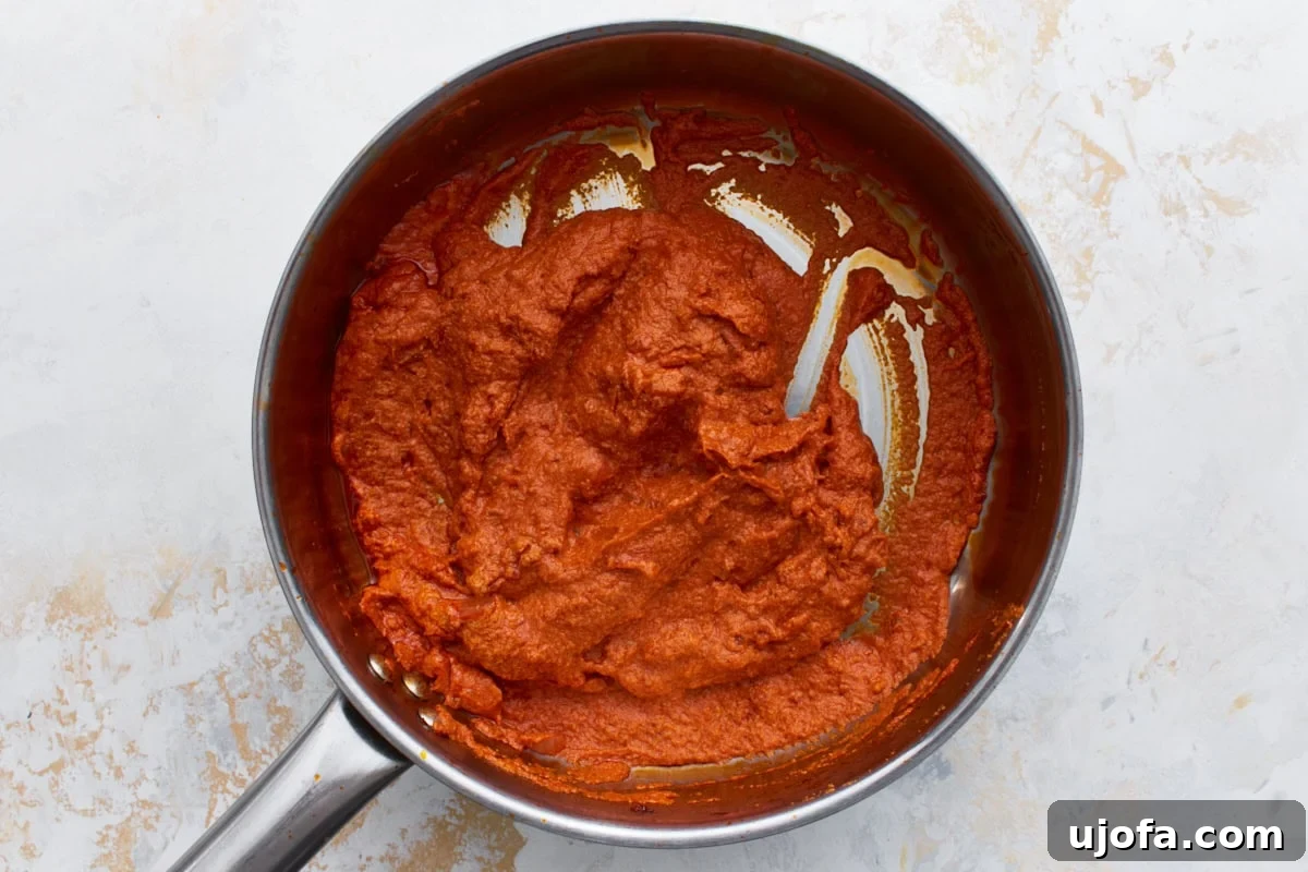 Thick tomato and vodka mixture in the skillet before cashew cream is stirred in.