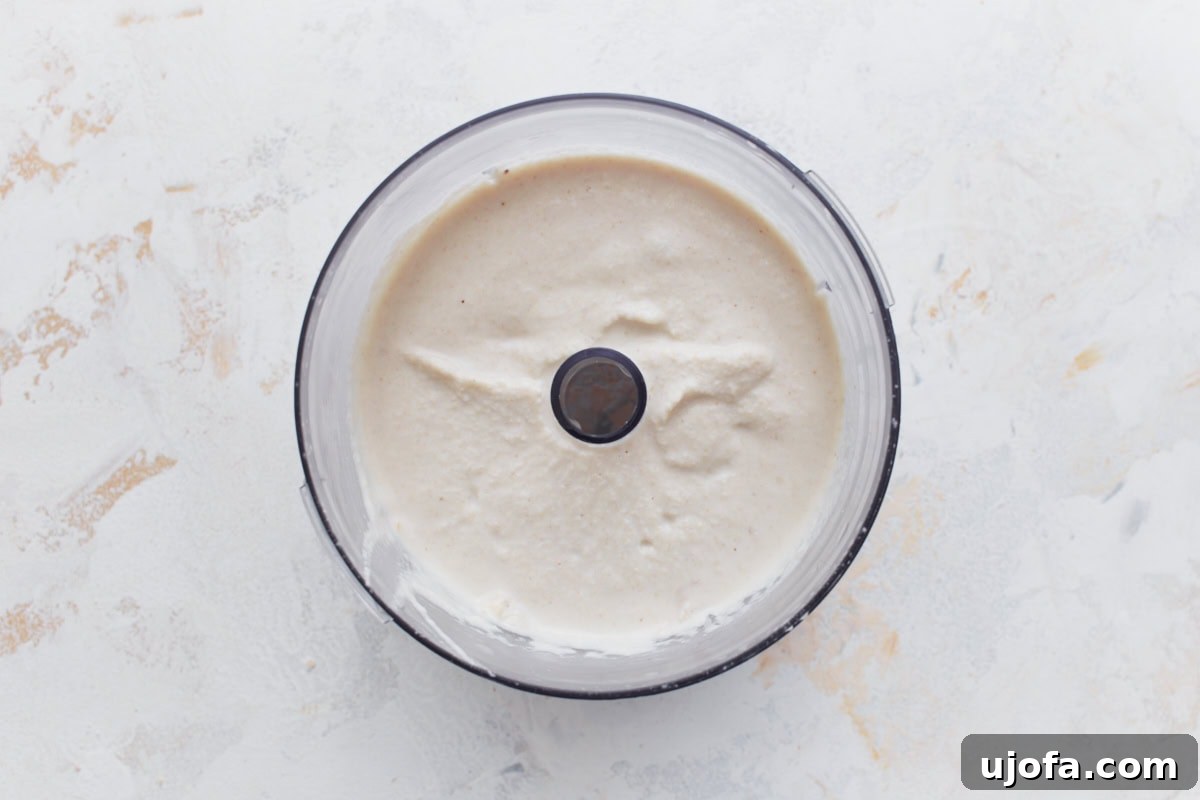 Smooth blended cashew cream in a food processor bowl, ready to be stirred into the vegan vodka sauce.