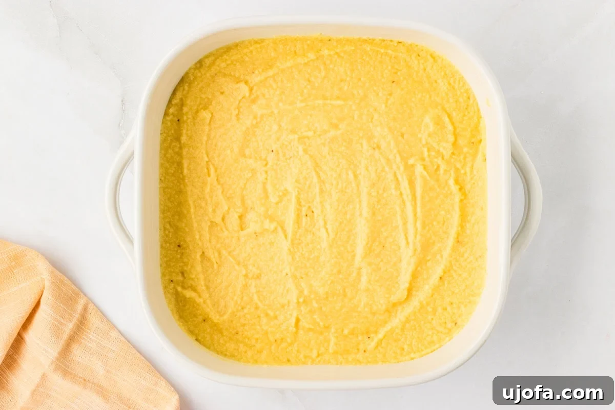 Guilt-Free Golden Cornbread 7 Cornbread batter spread evenly in a white baking dish before going into the oven, showcasing the smooth, ready-to-bake consistency.
