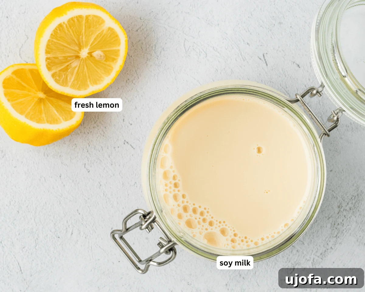 Two ingredients for vegan buttermilk: a carton of soy milk and a fresh lemon, on a light background.