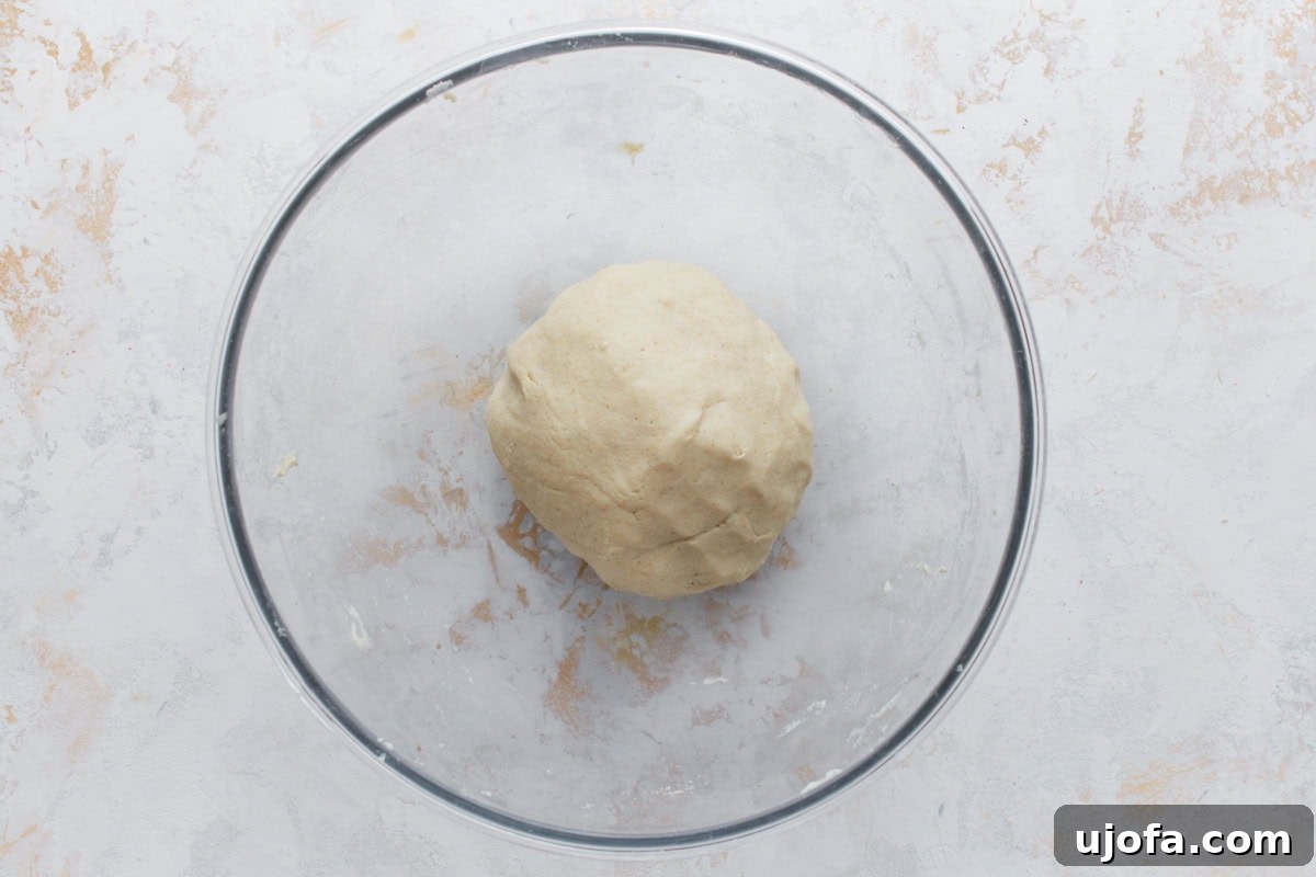Authentic Mexican Gorditas 5 A ball of gluten-free masa dough in a clear glass mixing bowl on a light surface, showing the initial mixing of dry and wet ingredients.