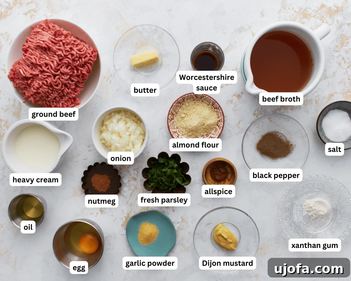 All fresh and dry ingredients for Keto Swedish Meatballs, including ground beef, onion, spices, and cream, are neatly laid out on a clean countertop, ready for preparation.