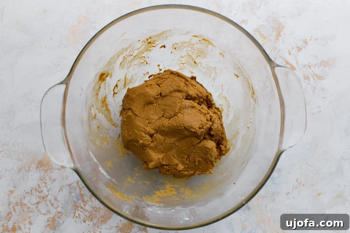 A glass bowl with the completed gingerbread dough, smooth and firm, ready to be chilled.