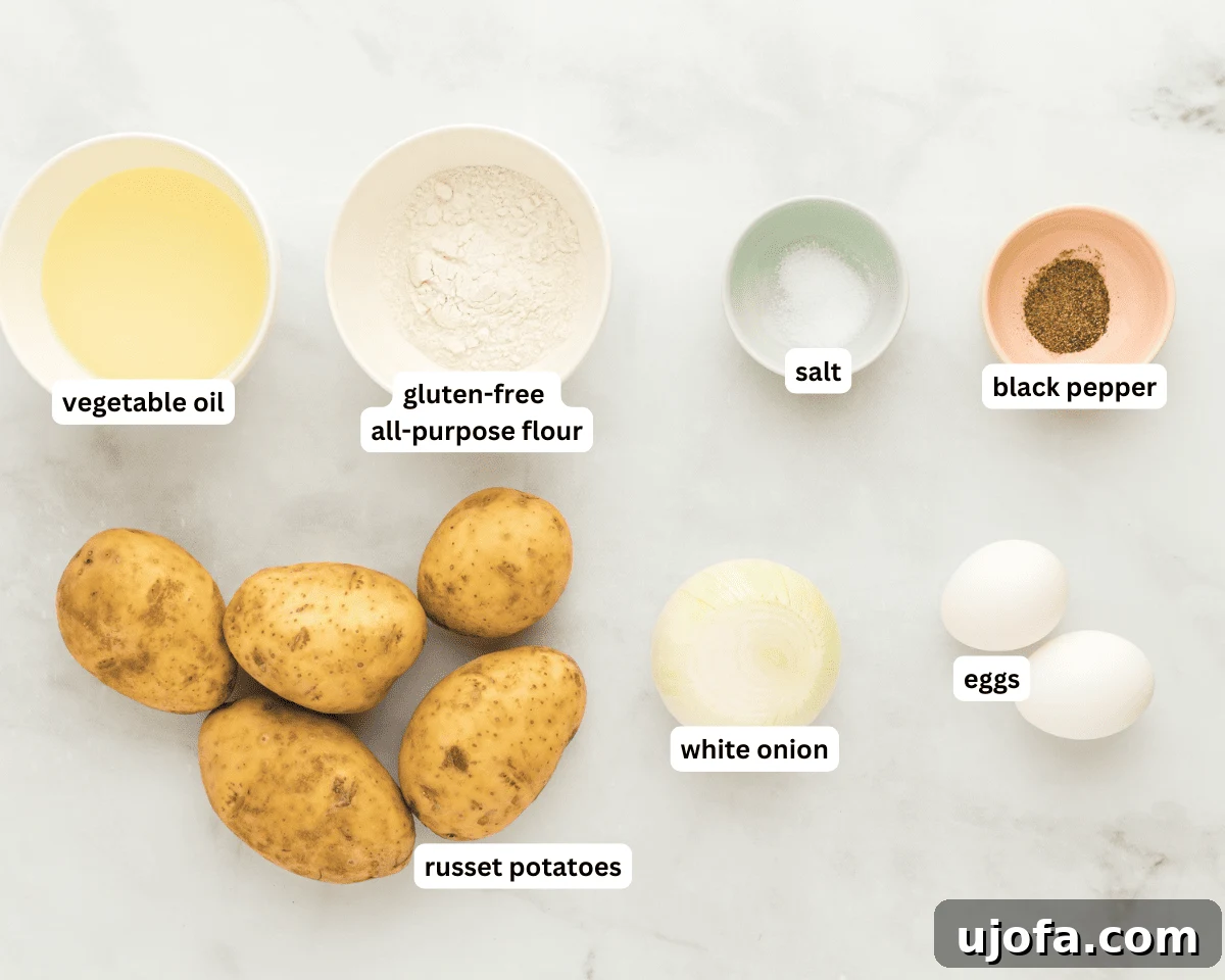Assortment of fresh ingredients for gluten-free potato latkes, including vibrant russet potatoes, a white onion, eggs, a bowl of gluten-free flour, salt, and pepper, all neatly arranged.