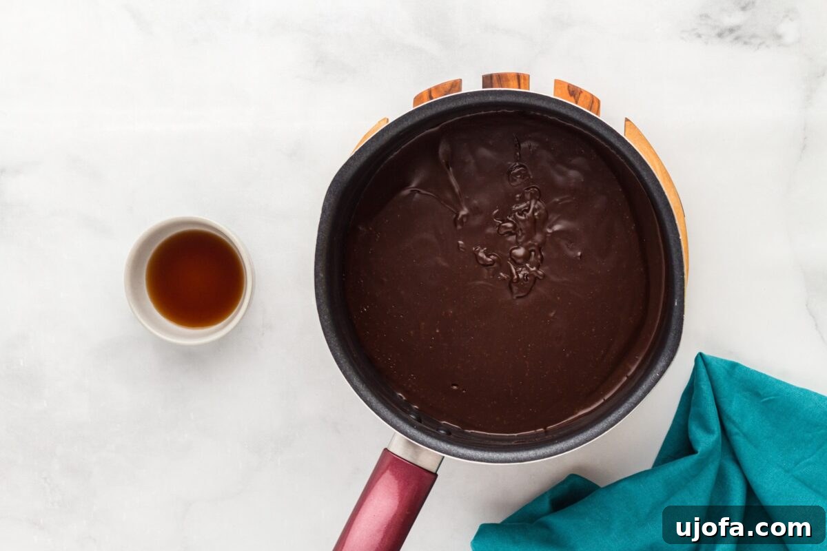 Thickened dairy-free chocolate pudding in a saucepan, smooth and glossy after cooking.