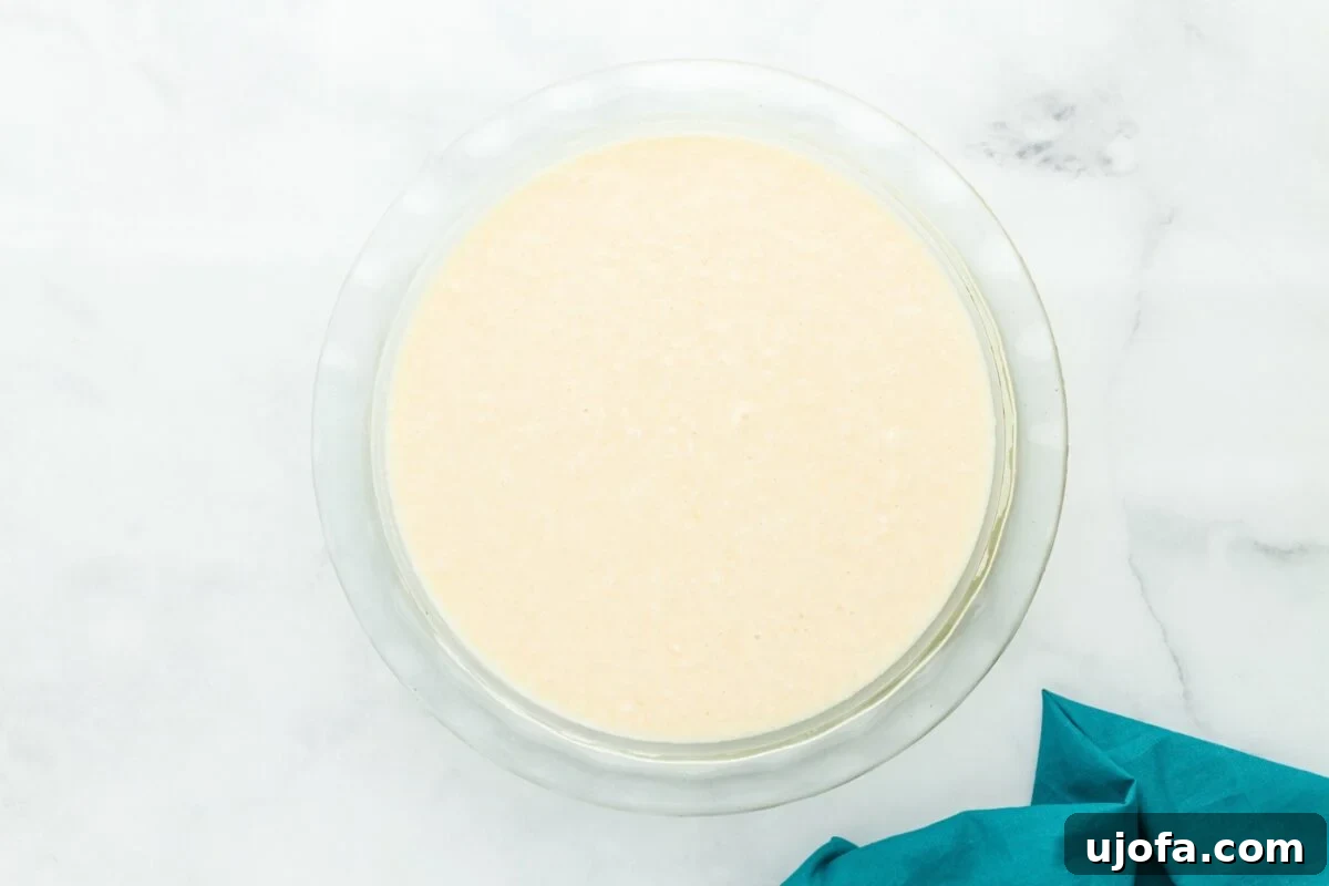Velvet Coconut Dream 9 A creamy, coconut-filled pie batter has just been poured into a clear glass 9-inch deep-dish pie plate, ready to be smoothed out and baked to perfection.