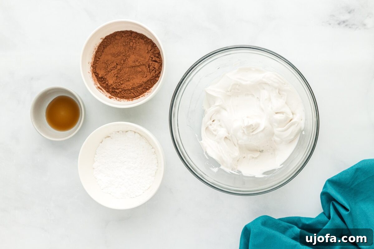Decadent Vegan Chocolate Treat 6 A mixing bowl filled with freshly whipped coconut cream next to small bowls of cocoa powder, powdered sugar, and vanilla extract.