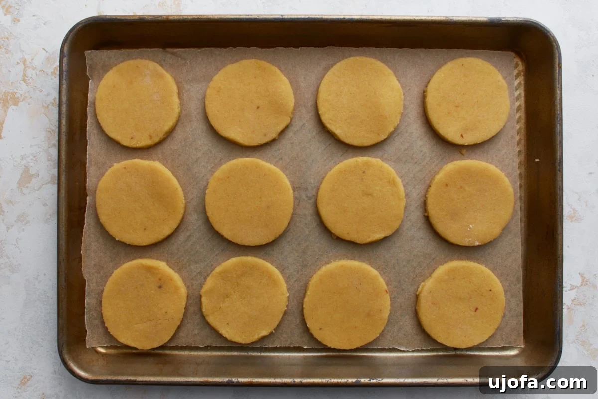 Unbaked almond flour sugar cookies arranged evenly on a parchment-lined baking sheet.