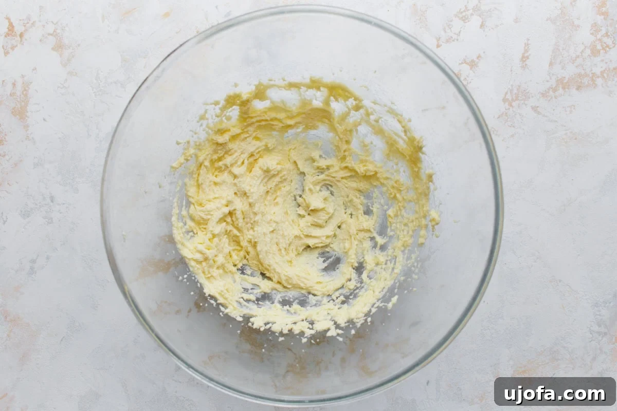 Creamed butter and sugar mixture in a glass bowl for almond flour sugar cookie dough.