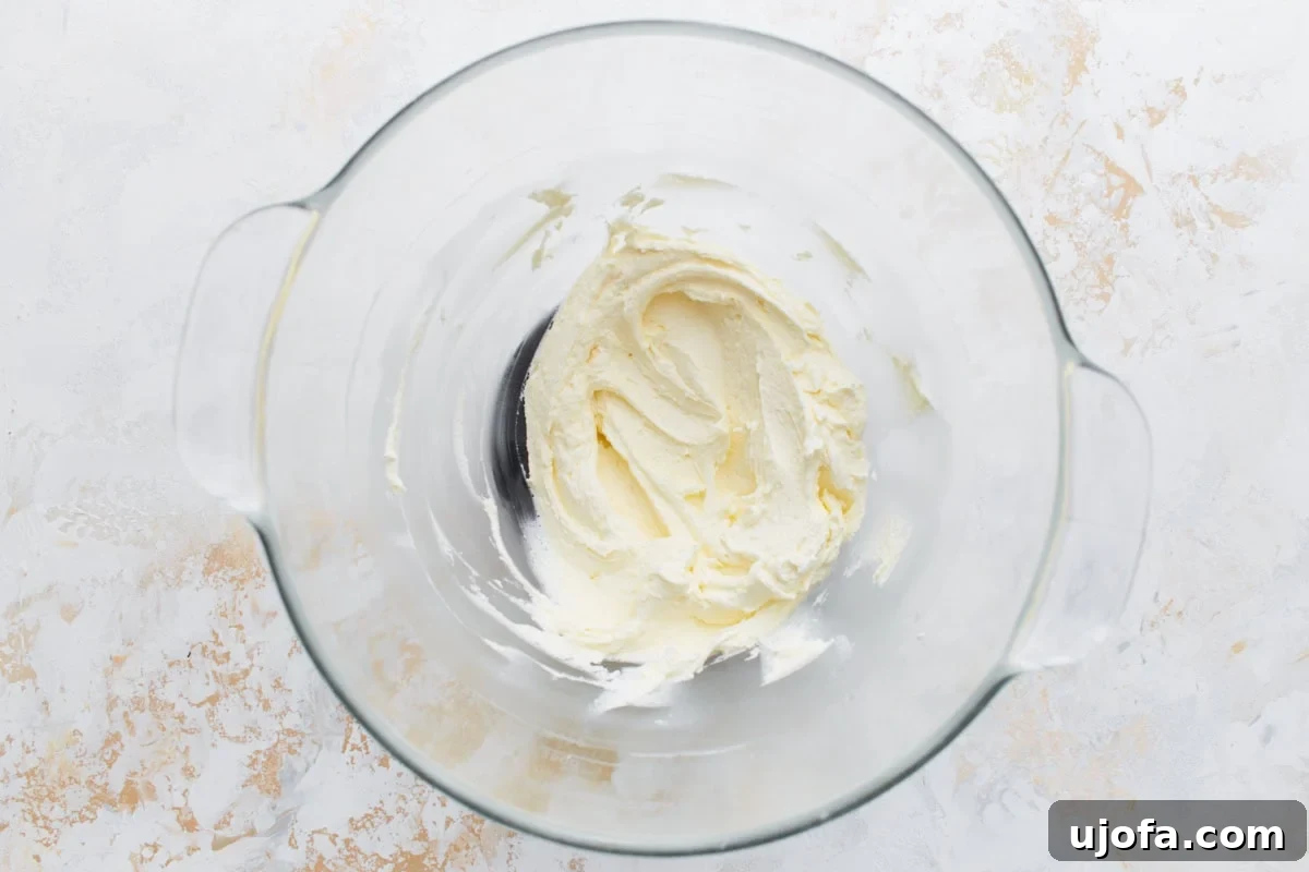 Smooth, creamy vanilla buttercream filling whipped to a light and fluffy consistency in a clear glass bowl.