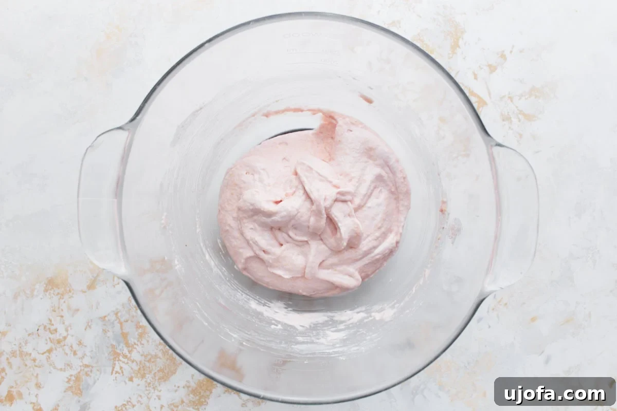 The macaron batter, now a soft pink, folded to the perfect 