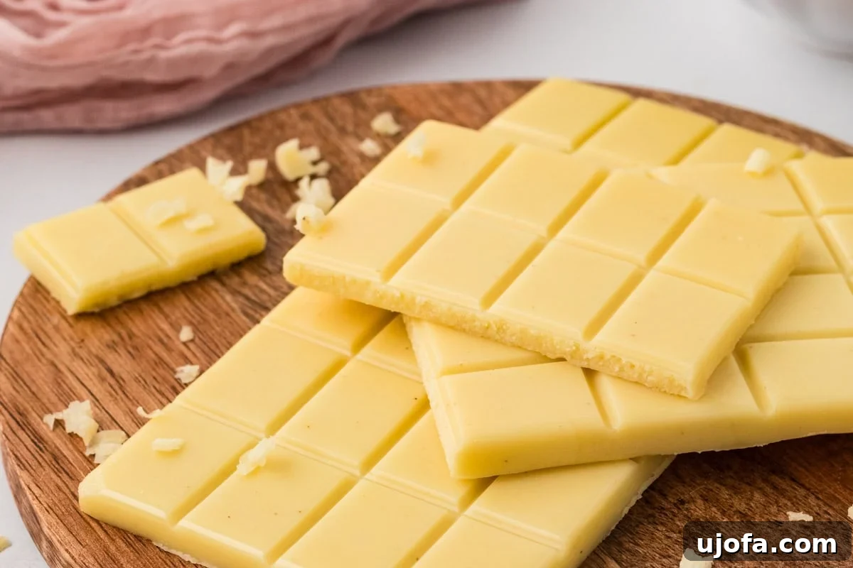 Close-up of vegan white chocolate bars on a wooden board showing smooth surface and texture.